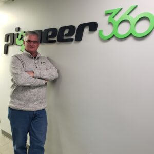 A man standing in front of a sign that says Pioneer-360.