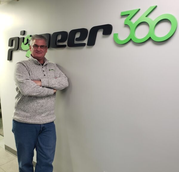 A man standing in front of a sign that says Pioneer-360.
