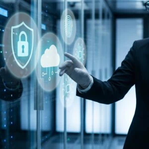 Person in a suit interacts with virtual cybersecurity icons, including a lock, cloud, fingerprint, and microchip, in a data center environment.