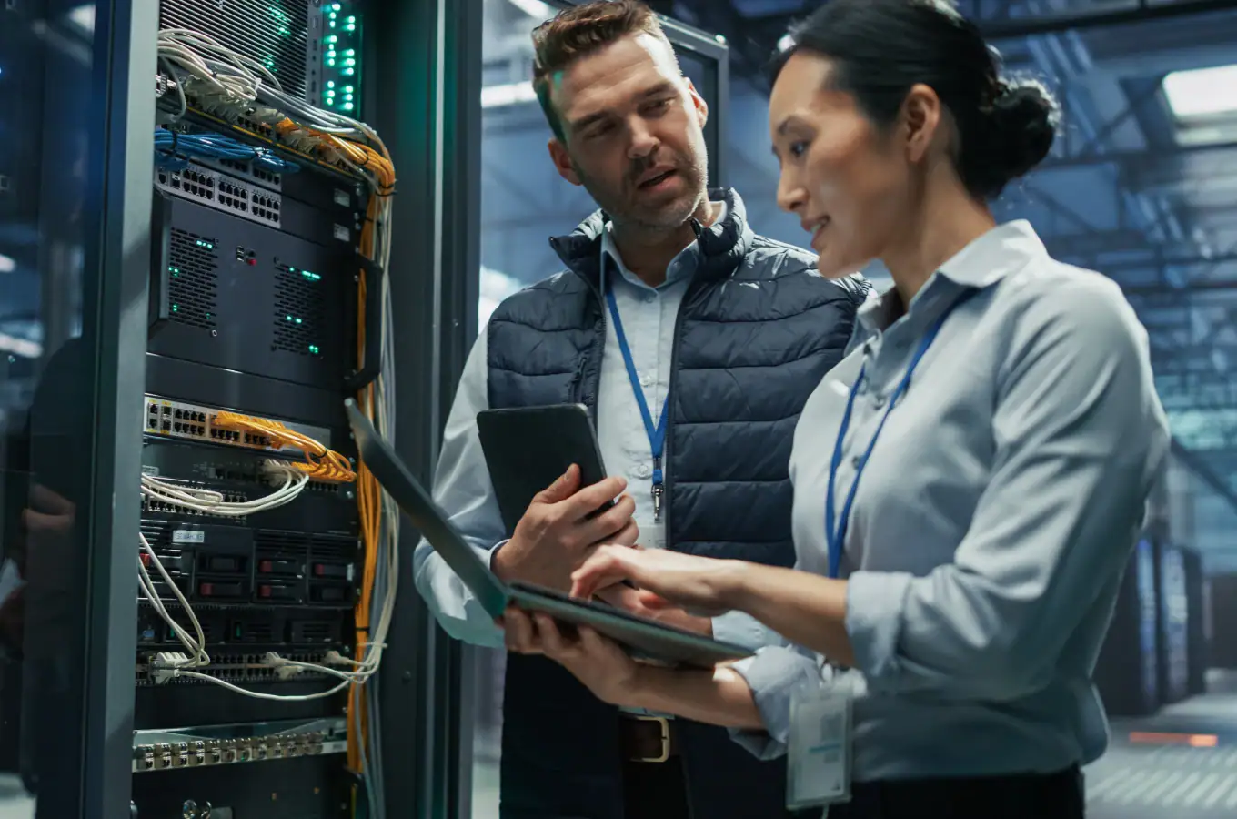 Two IT professionals working together in a server room